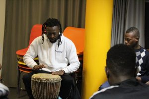 Un musicien joue du djembé devant un groupe de jeunes